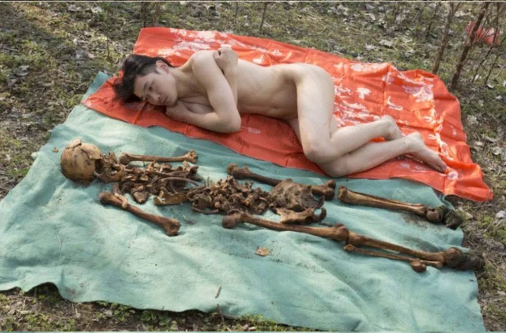 Artista chino posa desnudo junto a los huesos de su padre